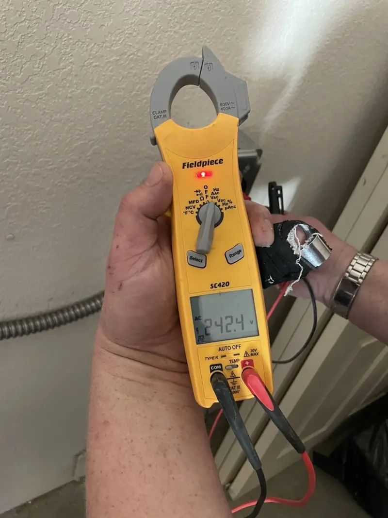 Voltage testing with clamp meter during Electrical Installation Services in Geddes